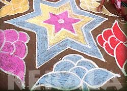 Woman decorate with vibrantly colored rice powder paintings during the Pongal festival 