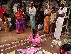 Woman decorate with vibrantly colored rice powder paintings during the Pongal festival 